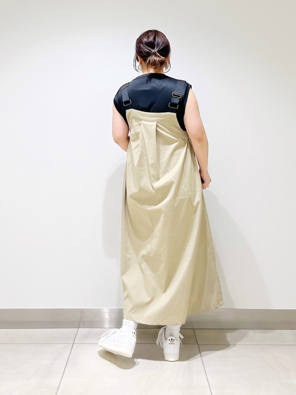 ブラック系のTシャツ/カットソー、ベージュ系のワンピース、ホワイト系のスニーカーを着用したレディースの春コーディネートの2枚目の写真