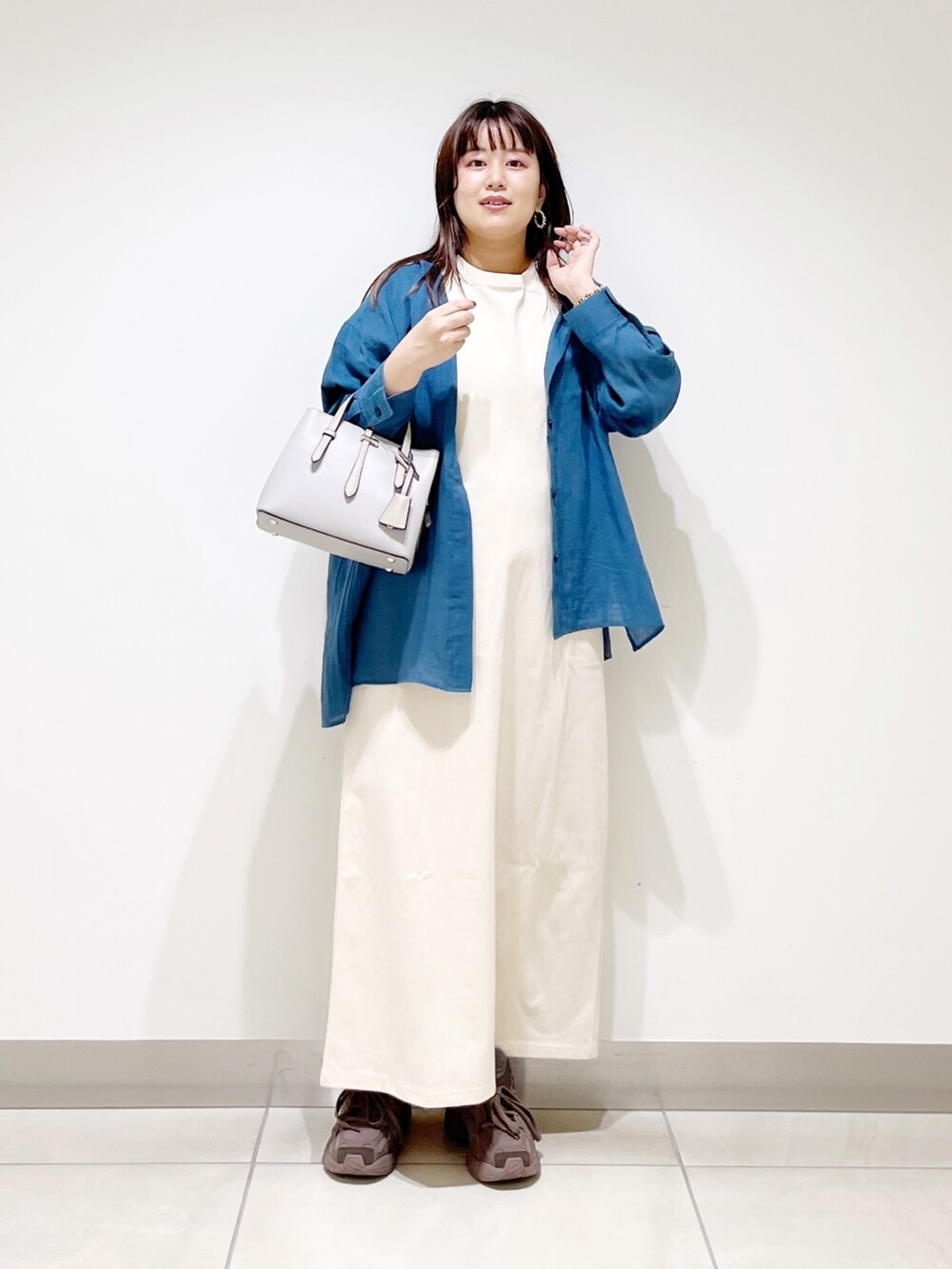 ブルー系のシャツ/ブラウス、ベージュ系のワンピース、グレー系のトートバッグを着用したレディースの夏コーディネートの10枚目の写真