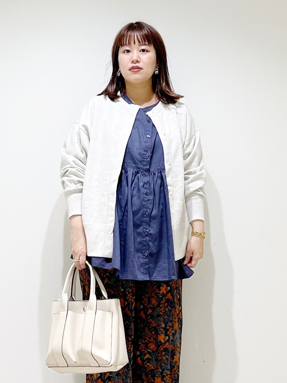 グレー系のカーディガン/ボレロ、ブルー系のシャツ/ブラウス、グレー系のトートバッグを着用したレディースの秋コーディネートの4枚目の写真