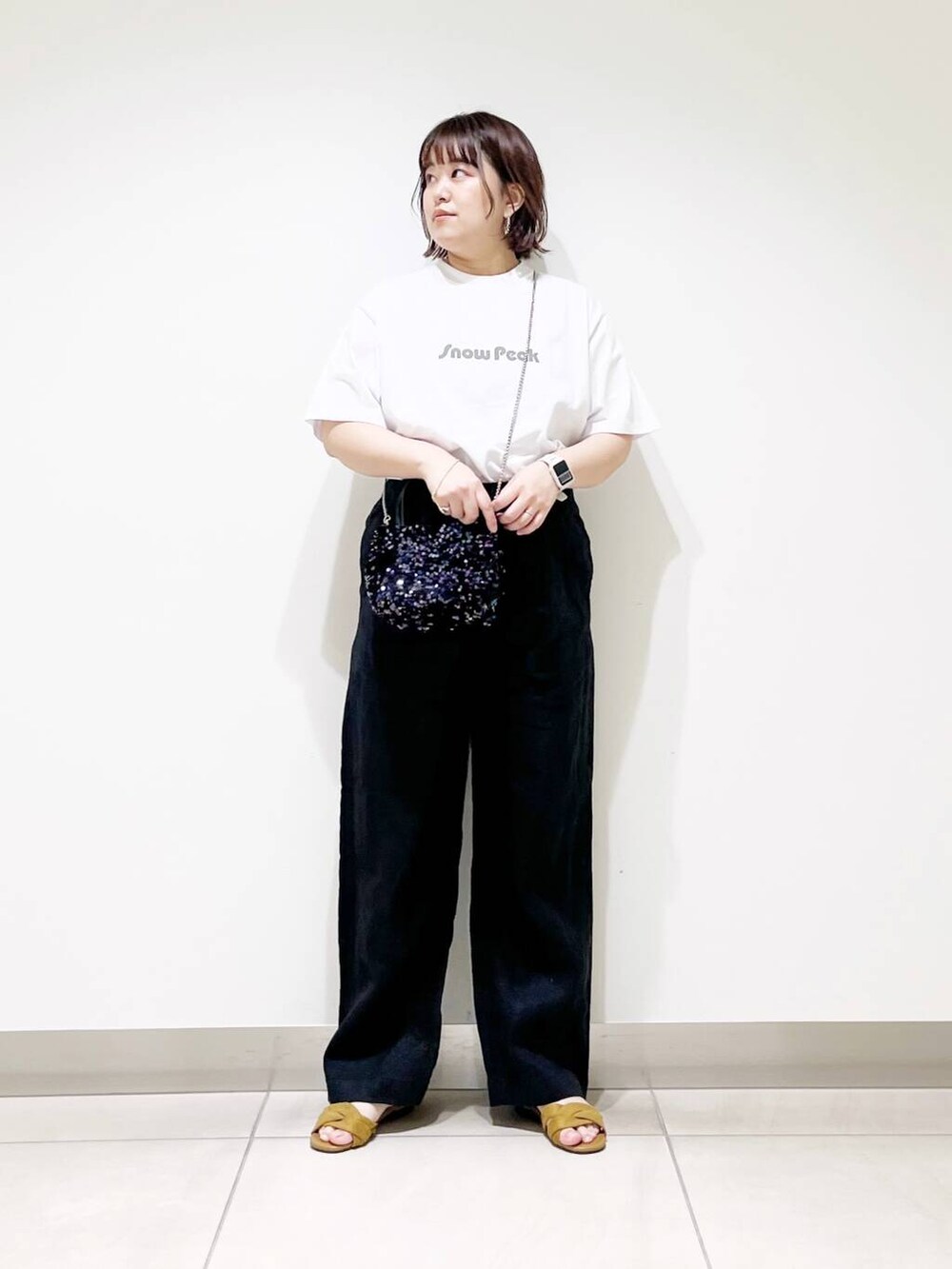 ブラック系のショルダーバッグ、ブラック系のその他パンツ、イエロー系のサンダルを着用したレディースの春コーディネートの7枚目の写真