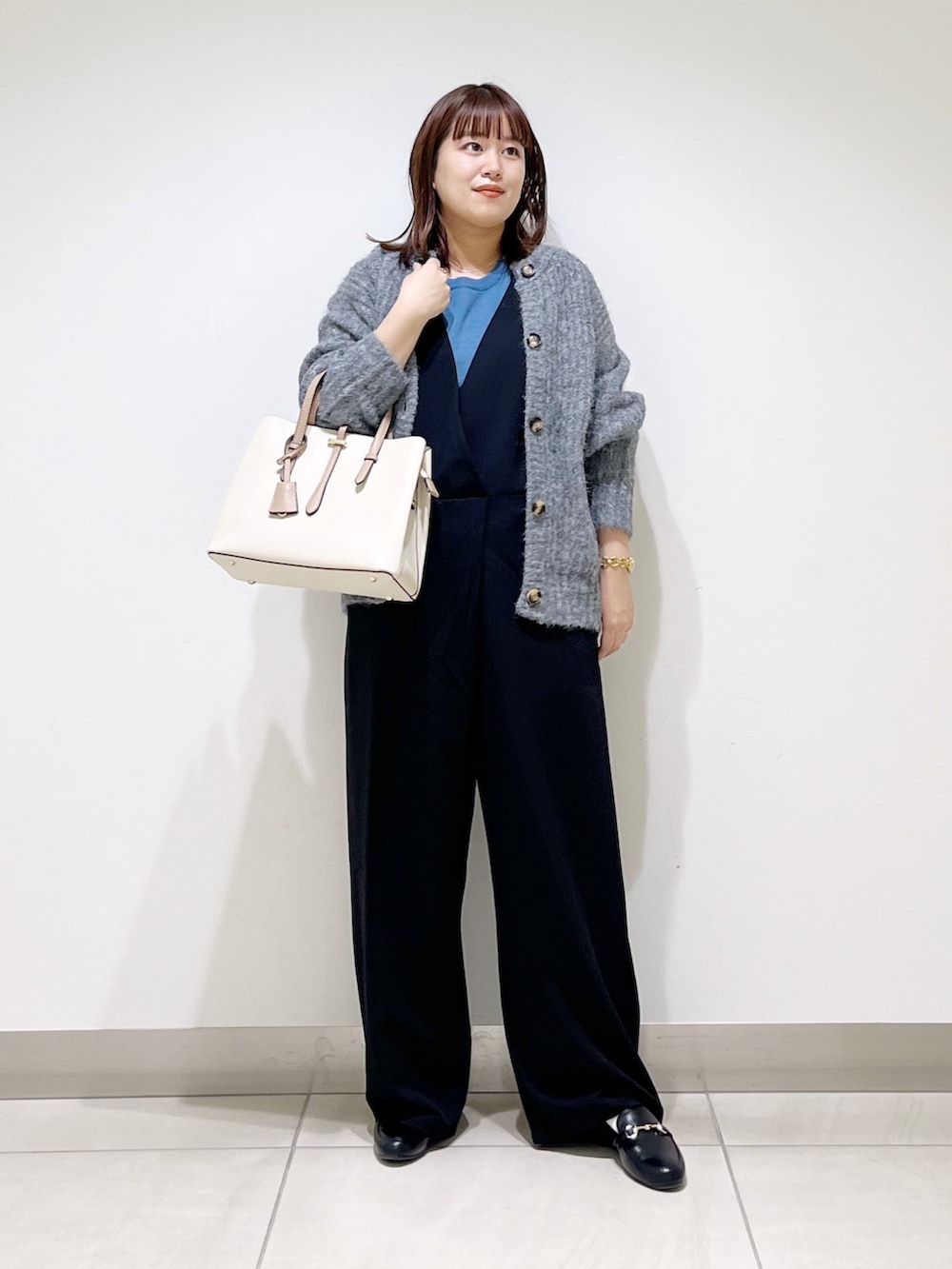 ブルー系のニット/セーター、グレー系のカーディガン/ボレロ、ブラック系のサロペット/オーバーオールを着用したレディースの秋コーディネートの5枚目の写真