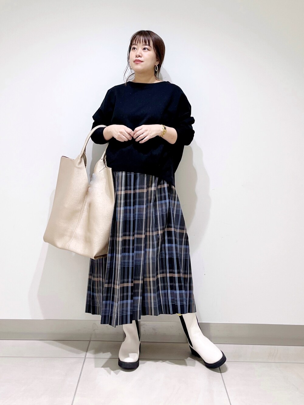 ブラック系のTシャツ/カットソー、ゴールド系のトートバッグ、ホワイト系のブーツを着用したレディースの秋コーディネートの9枚目の写真