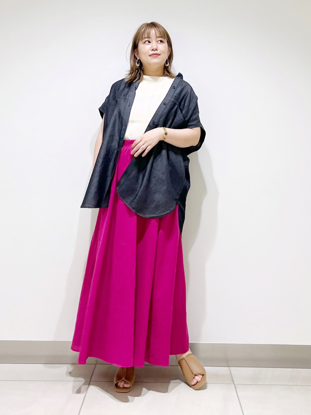 ブラック系のシャツ/ブラウス、ピンク系のスカート、ベージュ系のサンダルを着用したレディースの夏コーディネートの2枚目の写真