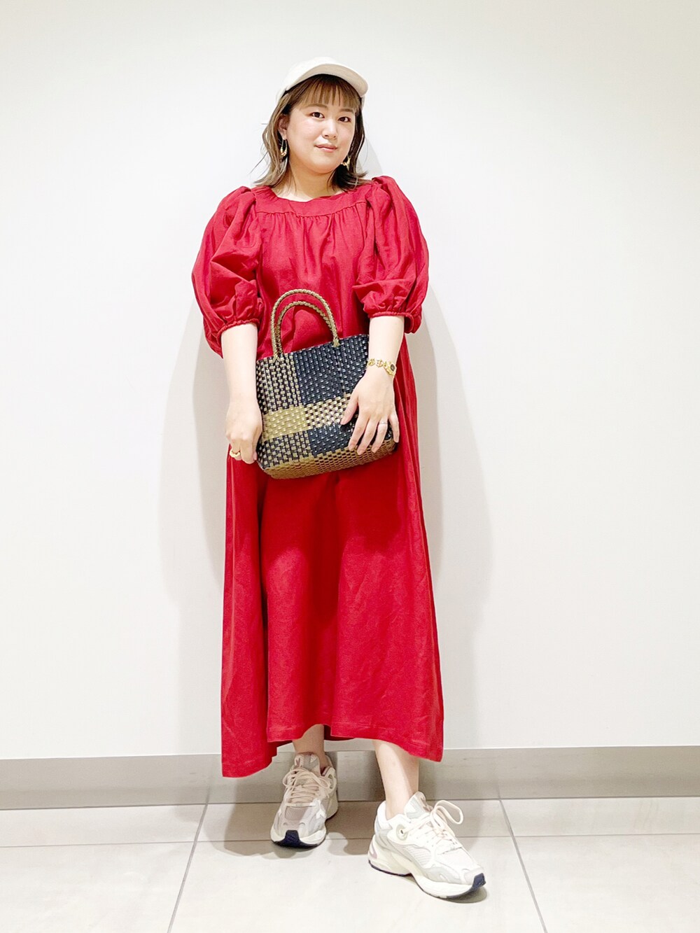 レッド系のワンピース、ホワイト系のスニーカー、ブラック系のトートバッグを着用したレディースの夏コーディネートの4枚目の写真