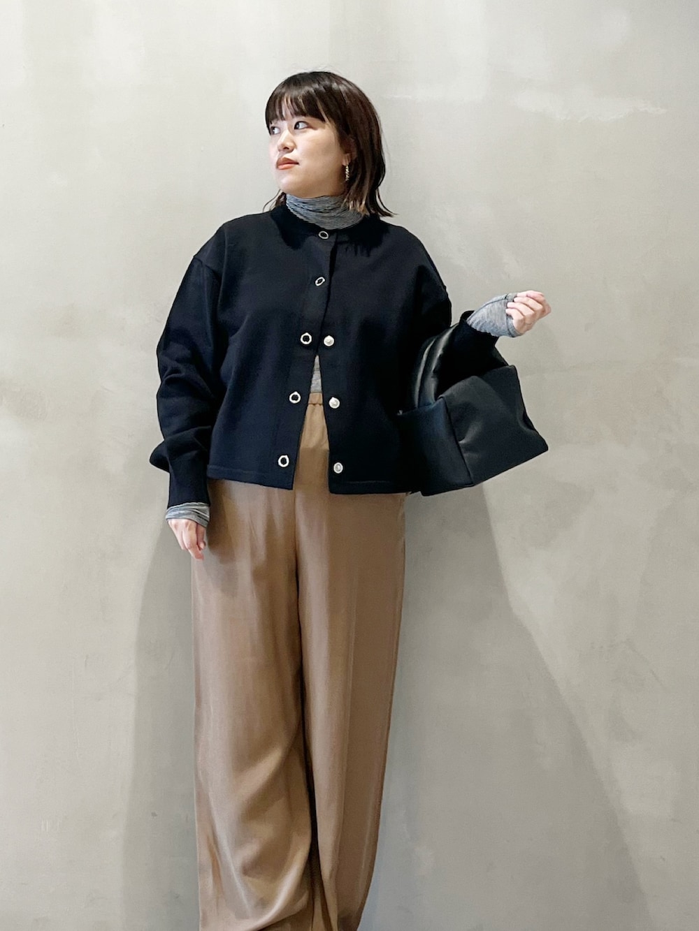 ブラック系のカーディガン/ボレロ、ベージュ系のその他パンツ、ブラック系のバッグを着用したレディースの秋コーディネートの3枚目の写真