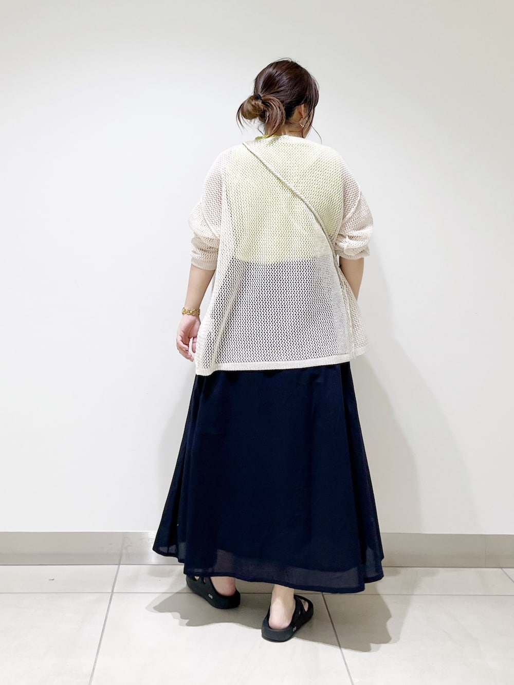 ホワイト系のカーディガン/ボレロ、ブラック系のショルダーバッグ、ブルー系のスカートを着用したレディースの春コーディネートの4枚目の写真