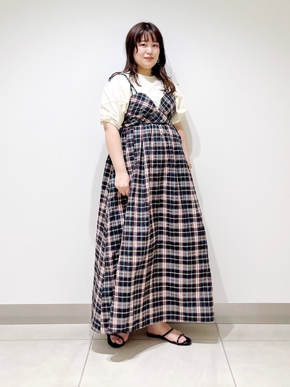 ブルー系のワンピース、ホワイト系のTシャツ/カットソー、ブラック系のサンダルを着用したレディースの春コーディネートの2枚目の写真