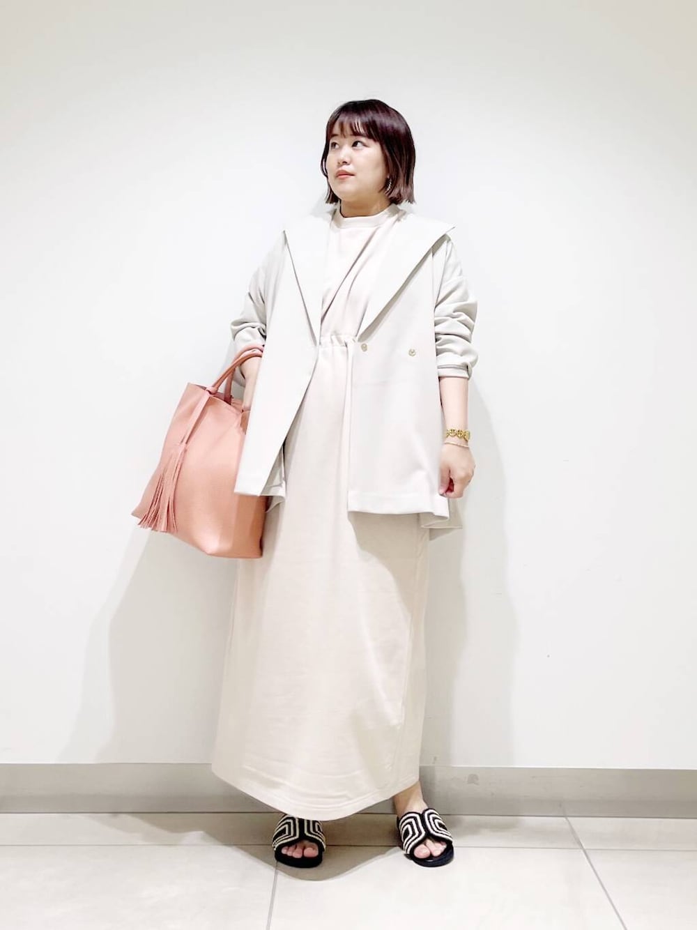 ピンク系のトートバッグ、ベージュ系のその他アウター、ベージュ系のワンピースを着用したレディースの春コーディネートの4枚目の写真