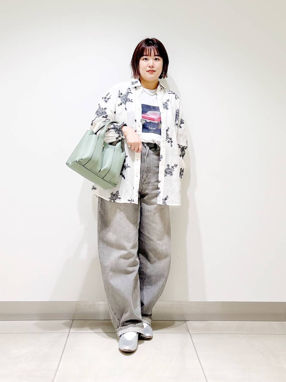 グリーン系のデニムパンツ、グリーン系のトートバッグ、シルバー系のパンプスを着用したレディースの春コーディネートの4枚目の写真