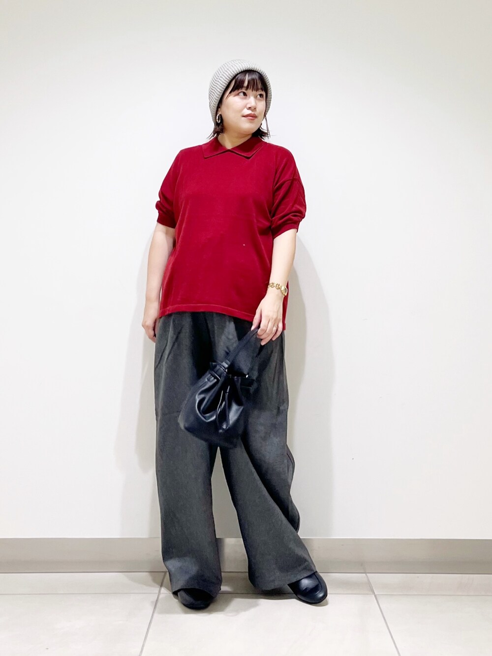 レッド系のニット/セーター、ブラック系のショルダーバッグ、グレー系のその他パンツを着用したレディースの秋コーディネートの4枚目の写真