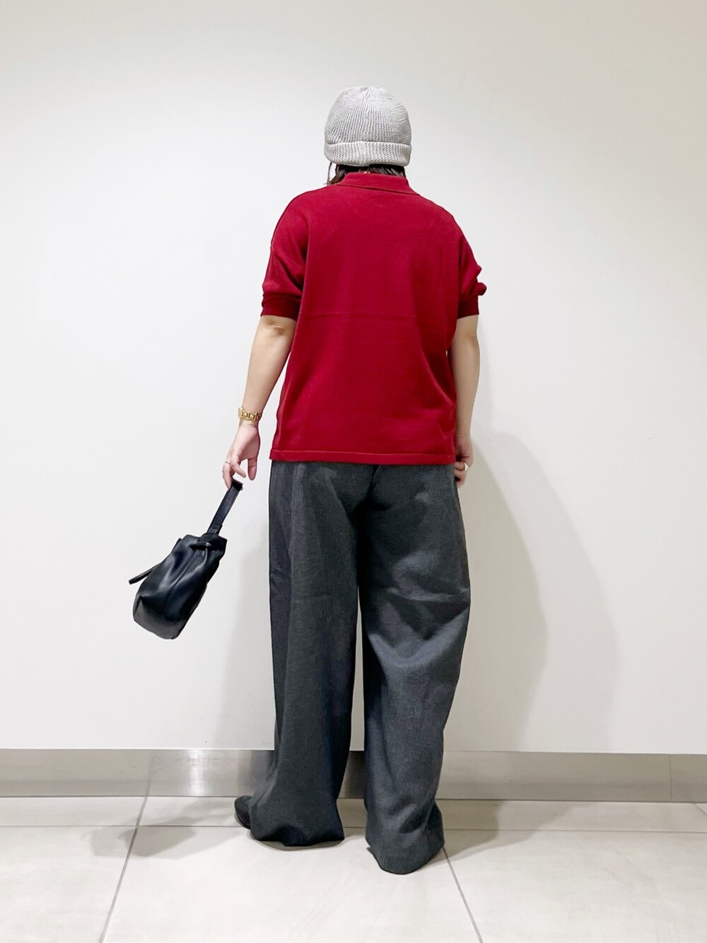 レッド系のニット/セーター、ブラック系のショルダーバッグ、グレー系のその他パンツを着用したレディースの秋コーディネートの6枚目の写真