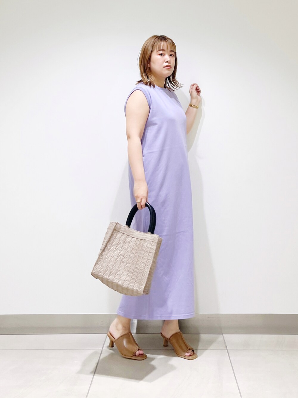 パープル系のワンピース、ベージュ系のトートバッグ、ベージュ系のサンダルを着用したレディースの夏コーディネートの2枚目の写真