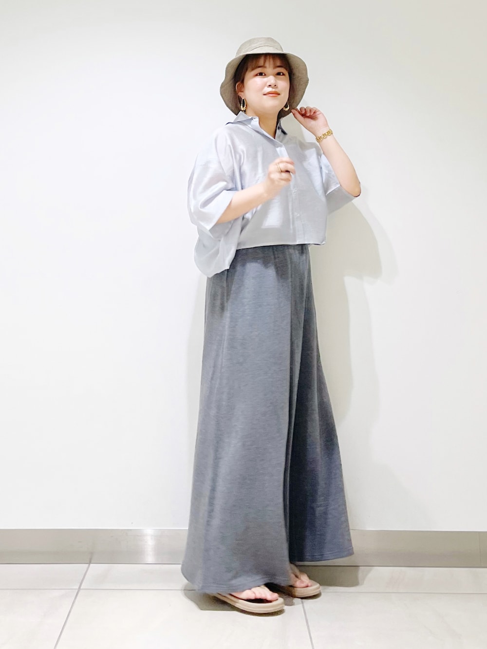 ブルー系のシャツ/ブラウス、グレー系のスカート、ベージュ系のサンダルを着用したレディースの春コーディネートの3枚目の写真