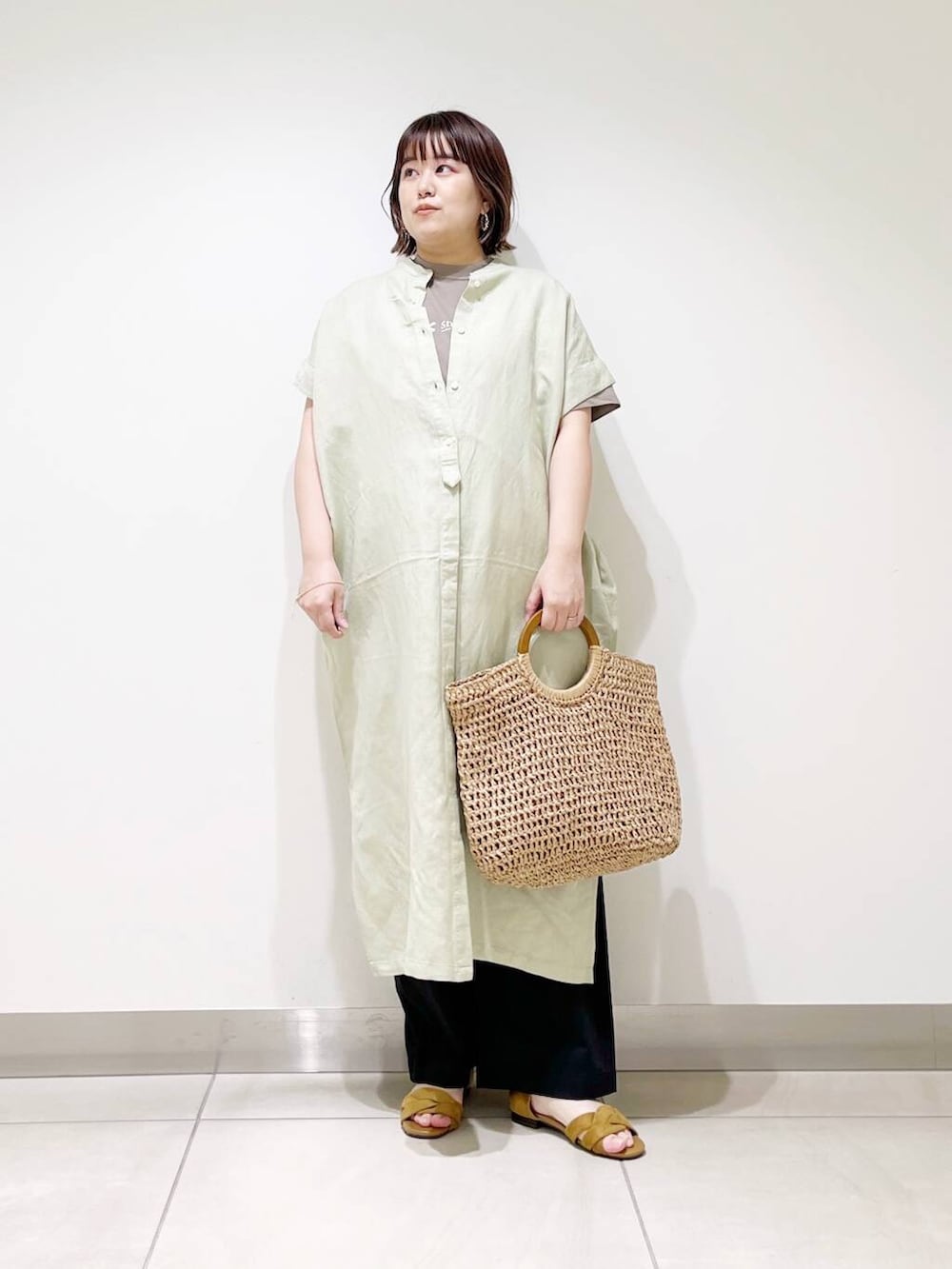 ブラック系のその他パンツ、グリーン系のワンピース、ベージュ系のトートバッグを着用したレディースの春コーディネートの7枚目の写真
