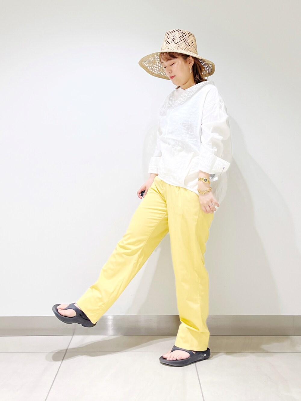 ホワイト系のシャツ/ブラウス、イエロー系のその他パンツ、ブラック系のサンダルを着用したレディースの春コーディネートの5枚目の写真