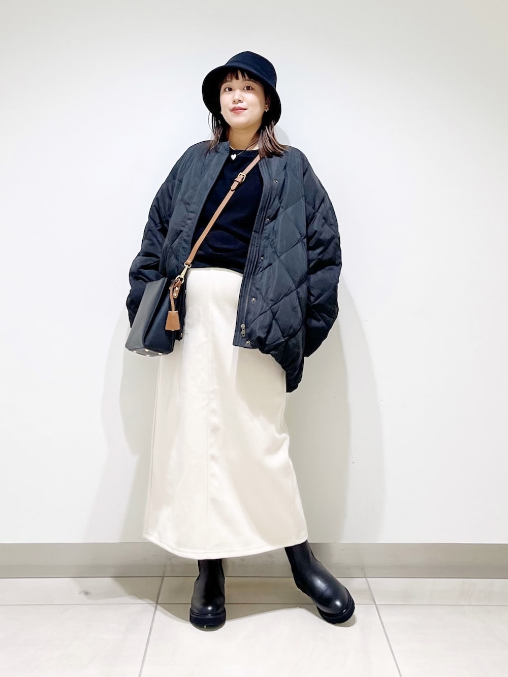 ブラック系のTシャツ/カットソー、ブラック系のその他アウター、ホワイト系のスカートを着用したレディースの秋コーディネートの2枚目の写真