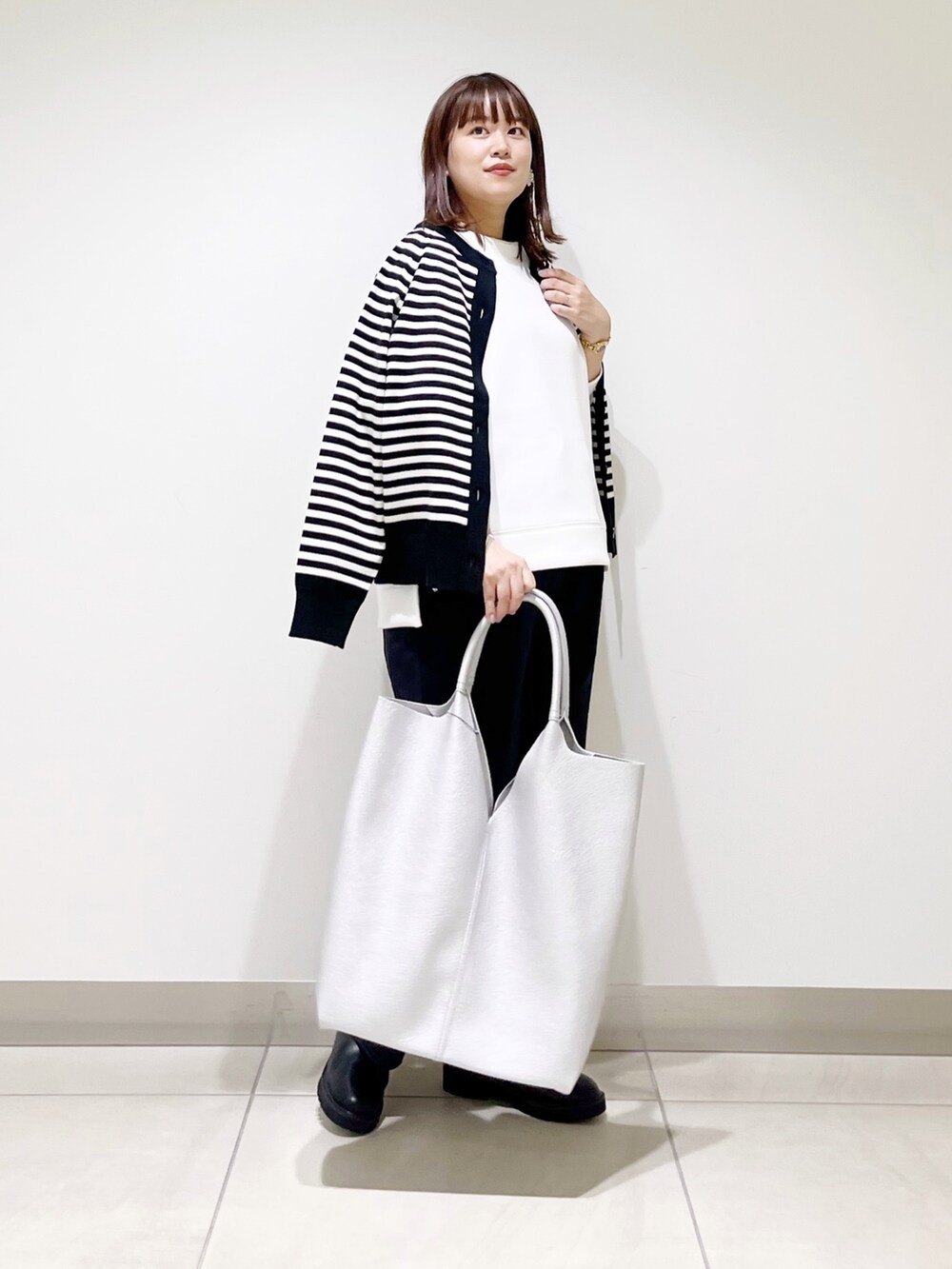 ホワイト系のTシャツ/カットソー、ブラック系のカーディガン/ボレロ、ブルー系のその他パンツを着用したレディースの秋コーディネートの8枚目の写真