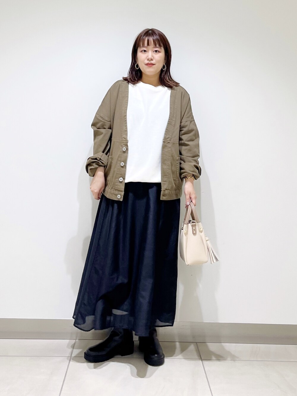 ホワイト系のTシャツ/カットソー、グリーン系のジャケット/アウター、ブラック系のスカートを着用したレディースの夏コーディネートの10枚目の写真