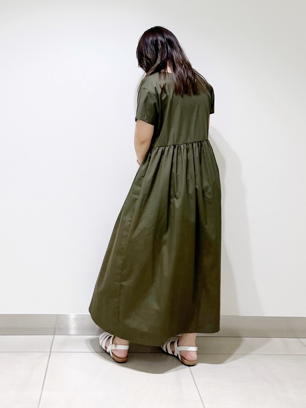 グリーン系のワンピース、ホワイト系のバッグ、ホワイト系のシューズを着用したレディースの春コーディネートの2枚目の写真