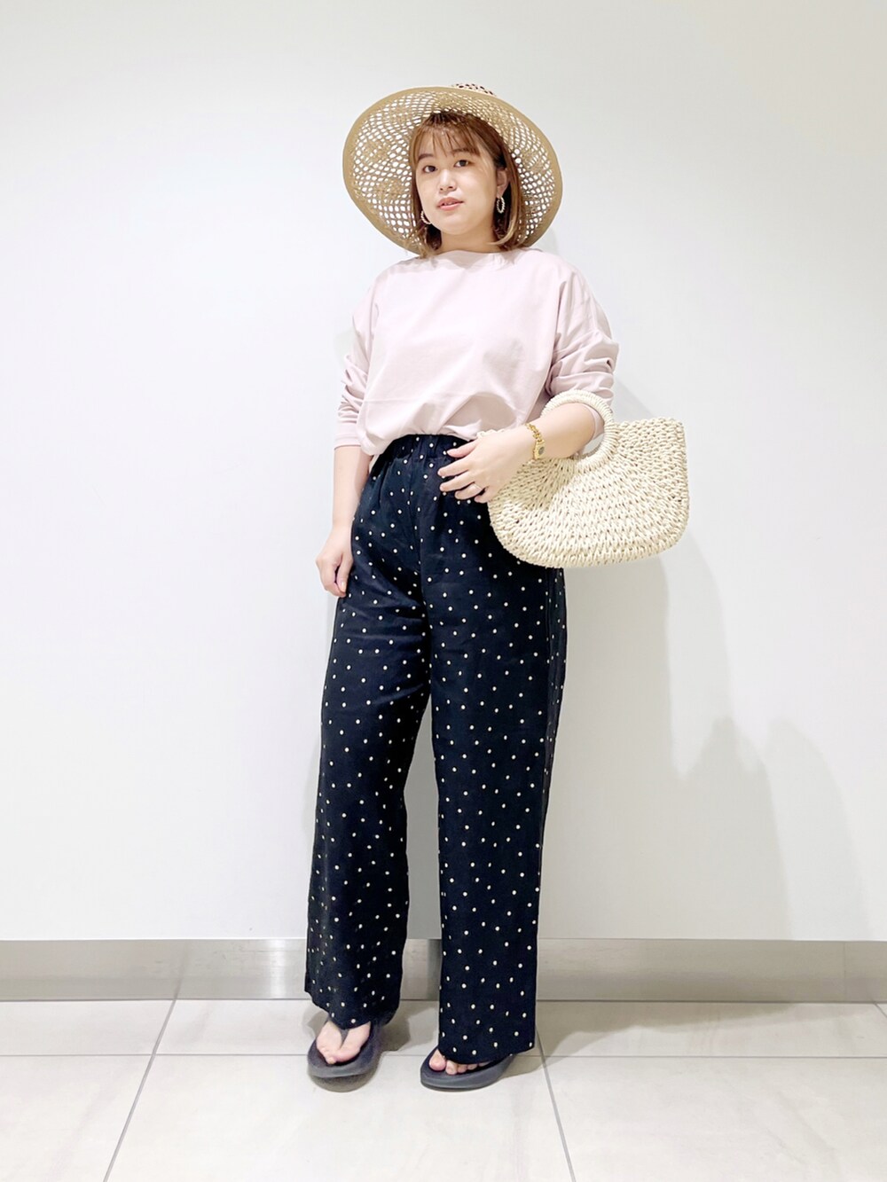 ブラック系のその他パンツ、ピンク系のTシャツ/カットソー、ホワイト系のハンドバッグを着用したレディースの春コーディネートの2枚目の写真