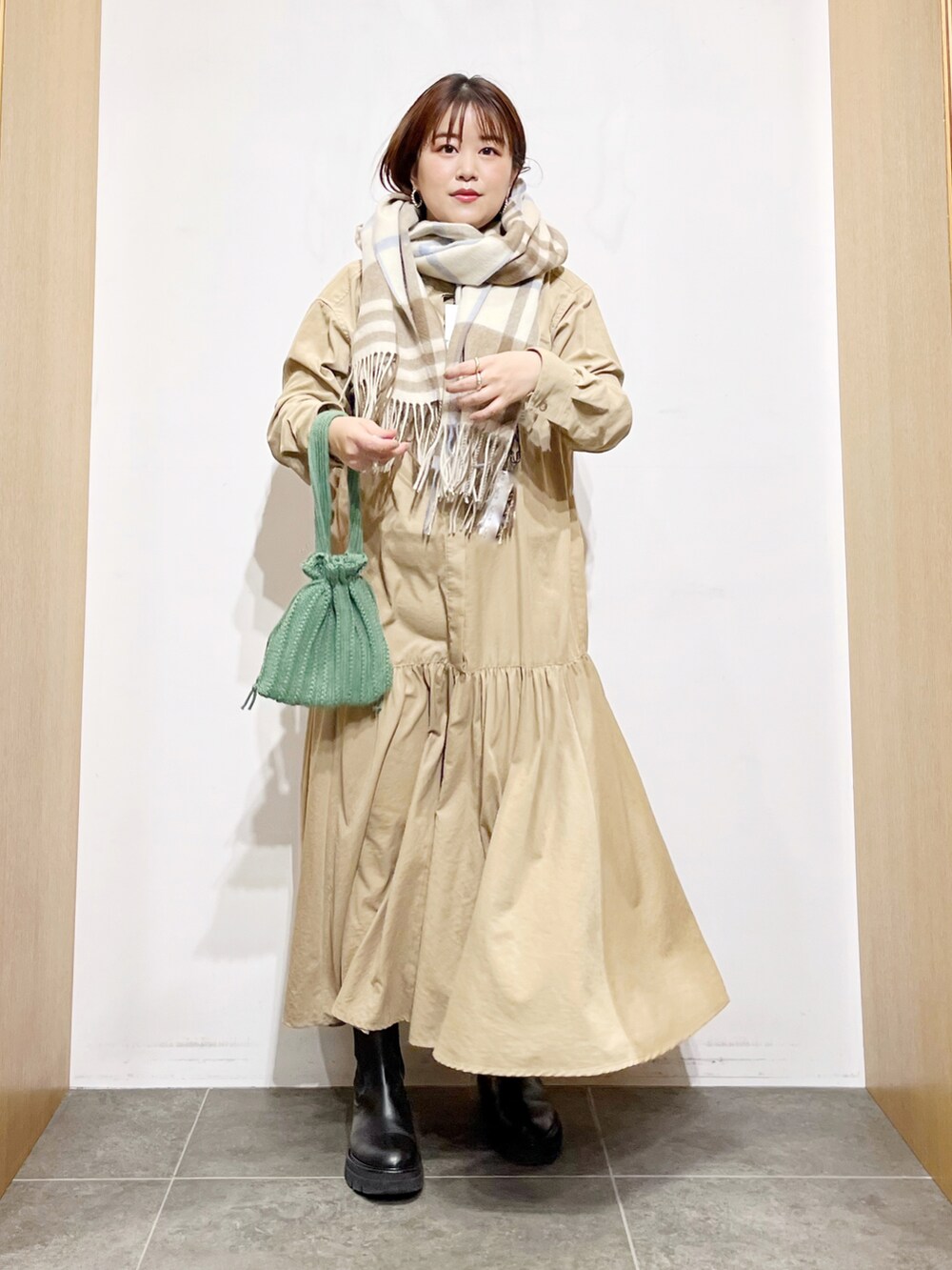 ベージュ系のワンピース、その他のバッグ、ブラック系のブーツを着用したレディースの秋コーディネートの2枚目の写真