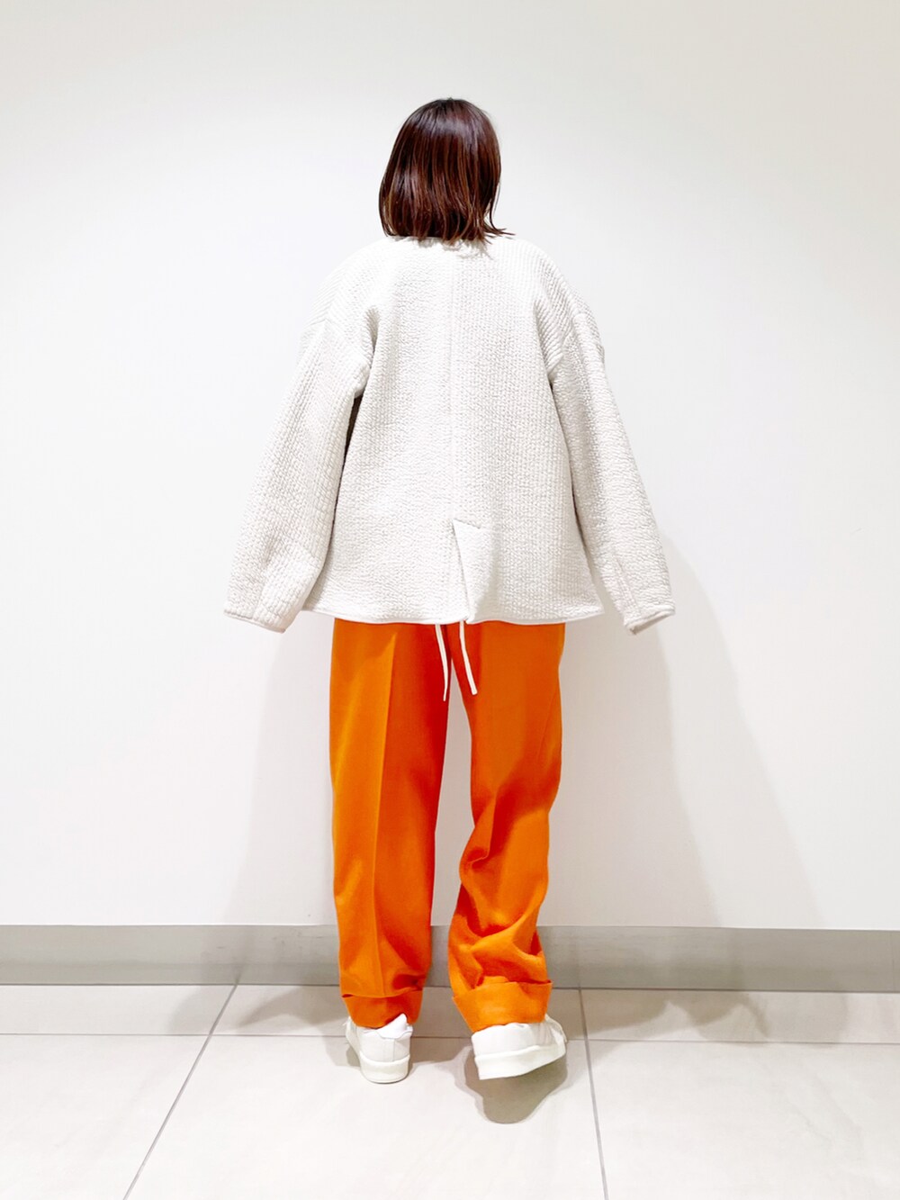 ホワイト系のシャツ/ブラウス、ホワイト系のノーカラージャケット、オレンジ系のその他パンツを着用したレディースの冬コーディネートの5枚目の写真