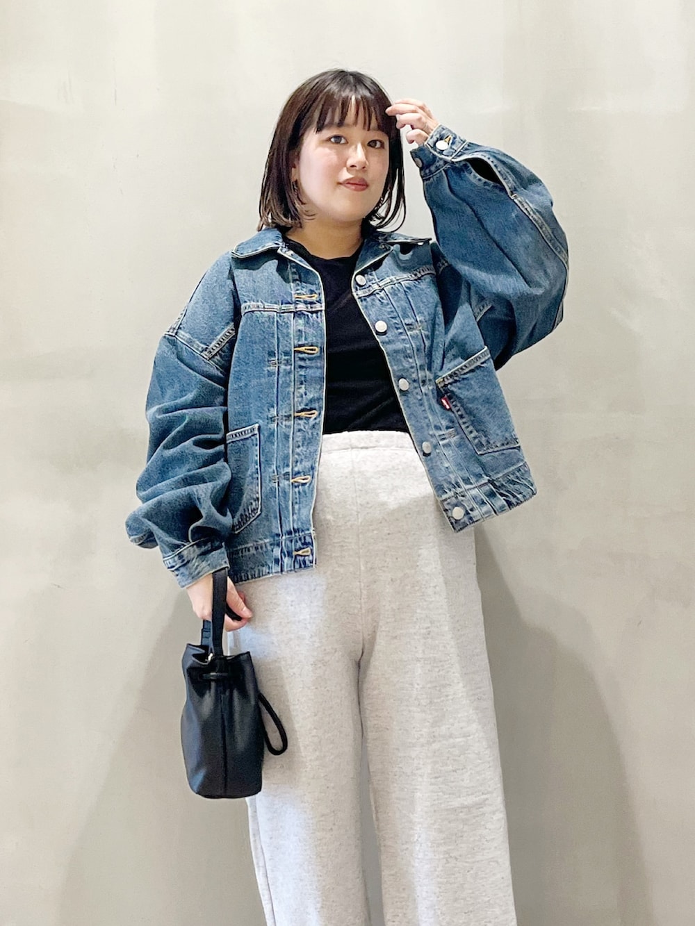 ブルー系のデニムジャケット、ブラック系のスニーカー、グレー系のその他パンツを着用したレディースの秋コーディネートの4枚目の写真