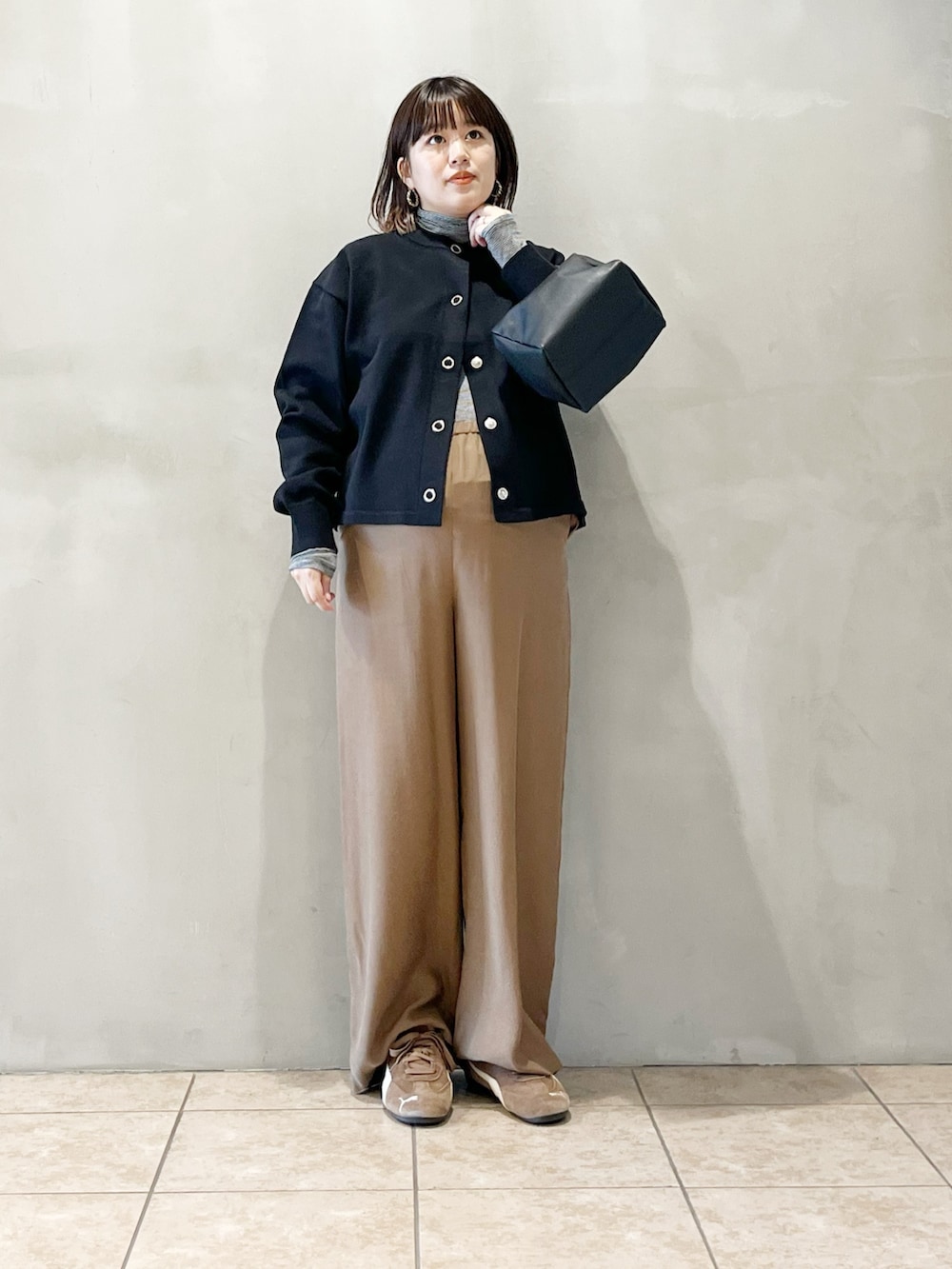 ブラック系のカーディガン/ボレロ、ベージュ系のその他パンツ、ブラック系のバッグを着用したレディースの秋コーディネートの5枚目の写真
