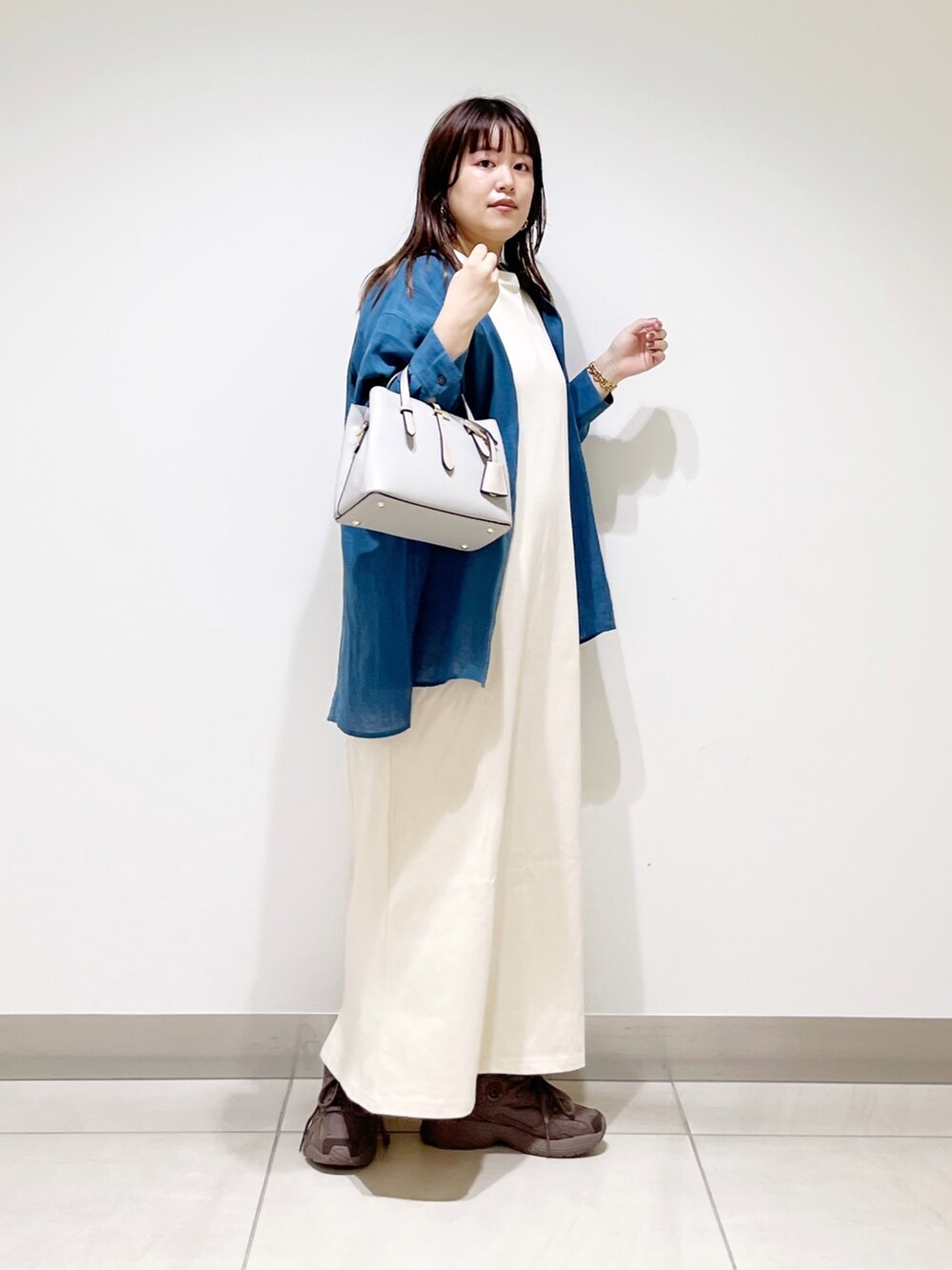 ブルー系のシャツ/ブラウス、ベージュ系のワンピース、グレー系のトートバッグを着用したレディースの夏コーディネートの8枚目の写真