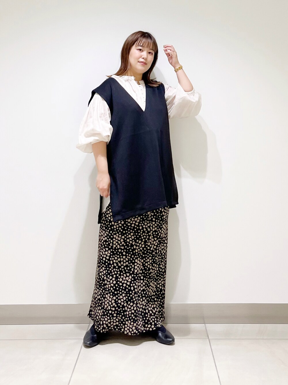 ブラック系のベスト、ホワイト系のシャツ/ブラウス、ブラック系のスカートを着用したレディースの夏コーディネートの2枚目の写真