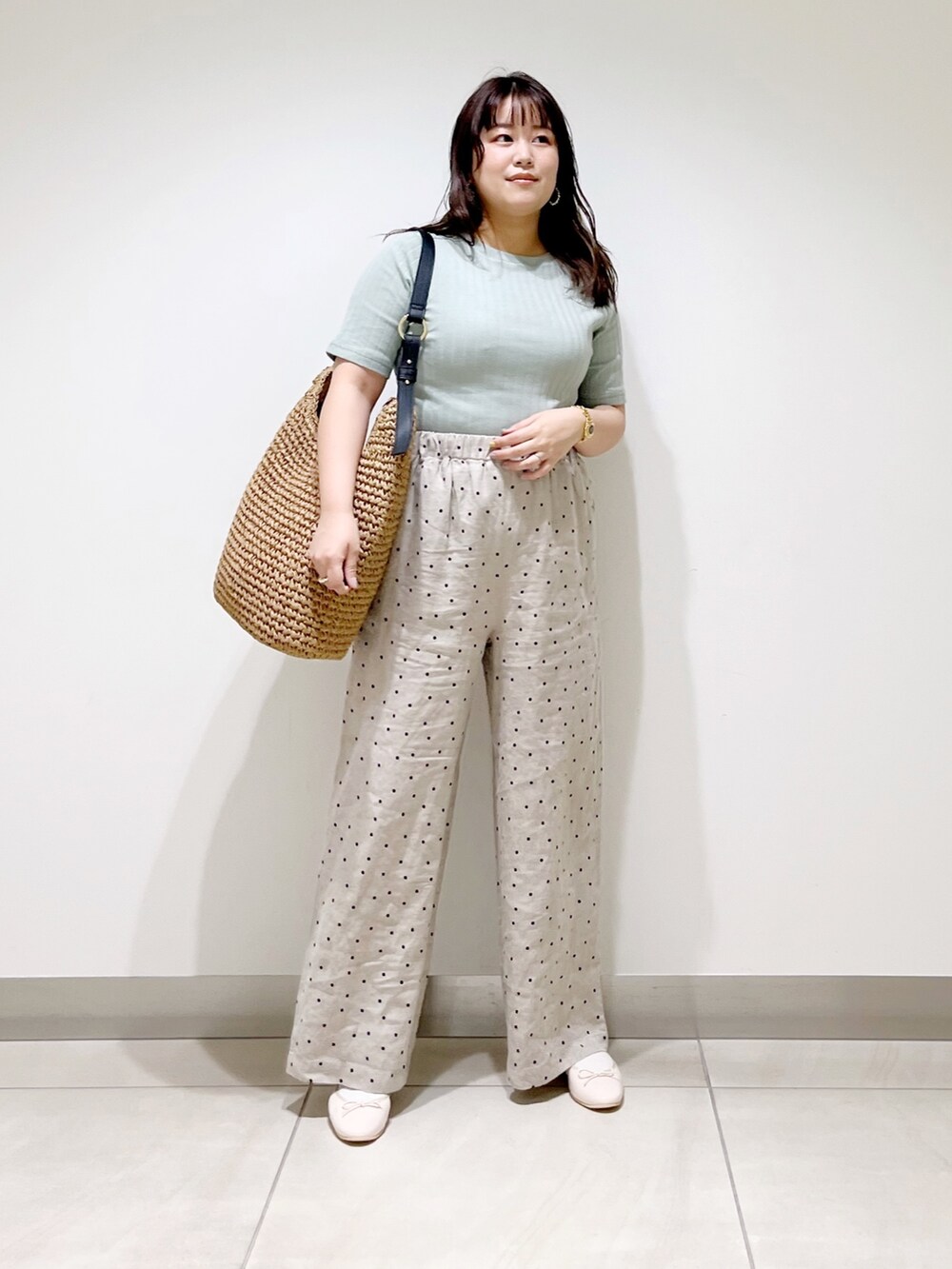 グリーン系のTシャツ/カットソー、ベージュ系のその他パンツ、ブラウン系のバッグを着用したレディースの春コーディネートの3枚目の写真