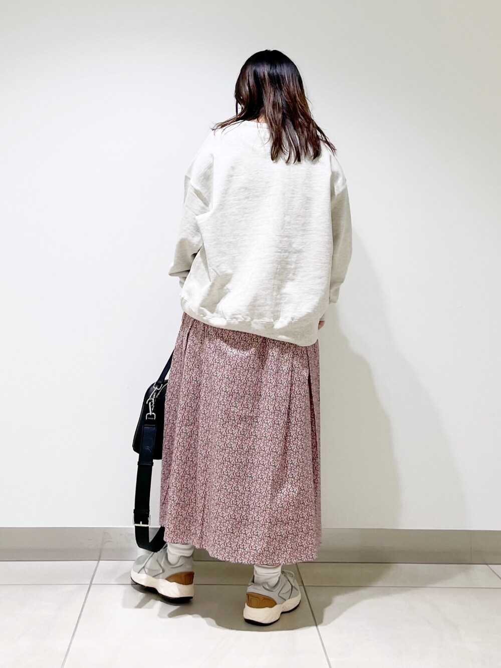 グレー系のスウェット、ピンク系のスカート、ブラック系のショルダーバッグを着用したレディースの春コーディネートの3枚目の写真