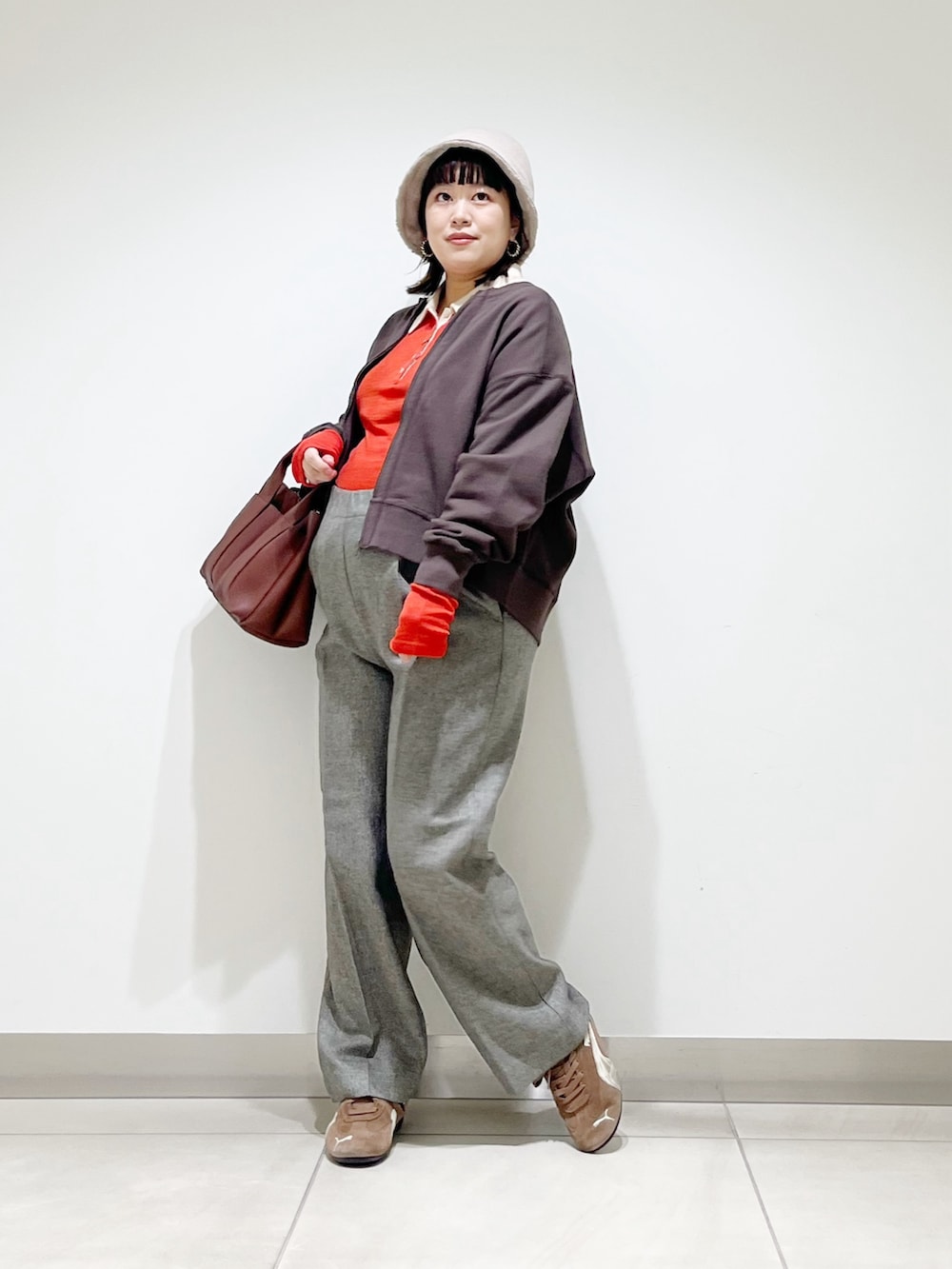 レッド系のニット/セーター、グレー系のその他パンツ、ブラック系のスニーカーを着用したレディースの秋コーディネートの6枚目の写真