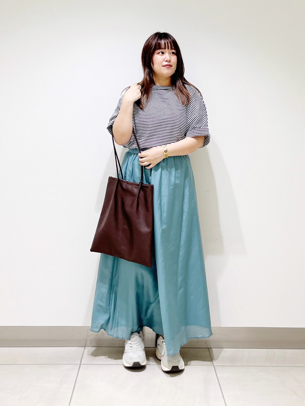 ホワイト系のTシャツ/カットソー、ホワイト系のスカート、ブラウン系のトートバッグを着用したレディースの夏コーディネートの3枚目の写真