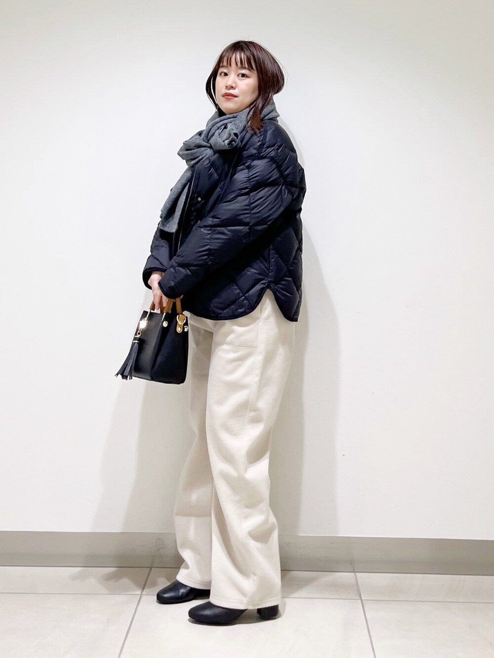 ブラック系のTシャツ/カットソー、ブラック系のダウンジャケット/コート、ブラック系のトートバッグを着用したレディースの秋コーディネートの6枚目の写真