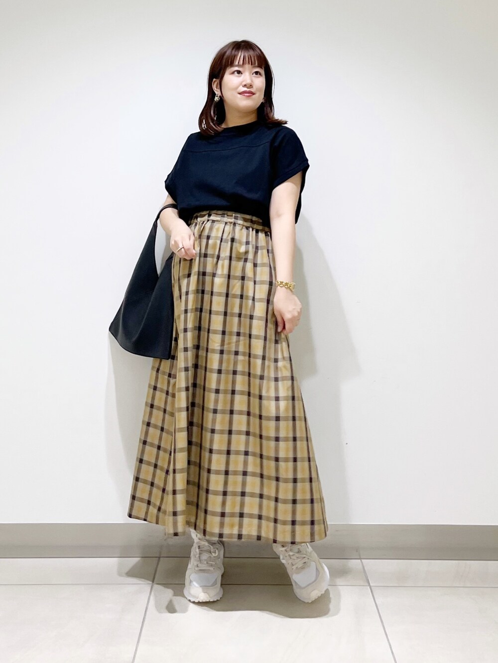 ホワイト系のスニーカー、ブラック系のTシャツ/カットソー、ブラック系のトートバッグを着用したレディースの秋コーディネートの8枚目の写真