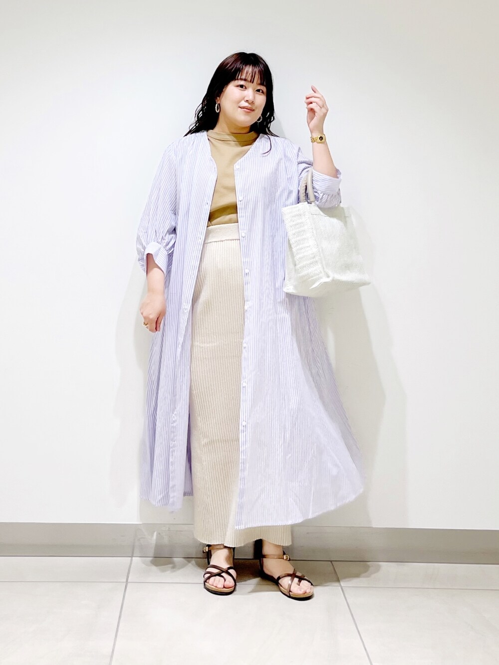 ベージュ系のTシャツ/カットソー、ベージュ系のスカート、パープル系のワンピースを着用したレディースの春コーディネートの8枚目の写真