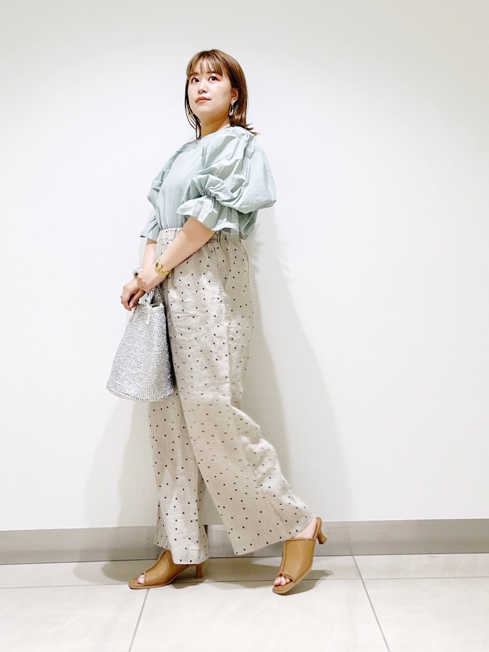 ベージュ系のその他パンツ、グリーン系のシャツ/ブラウス、シルバー系のトートバッグを着用したレディースの夏コーディネートの3枚目の写真