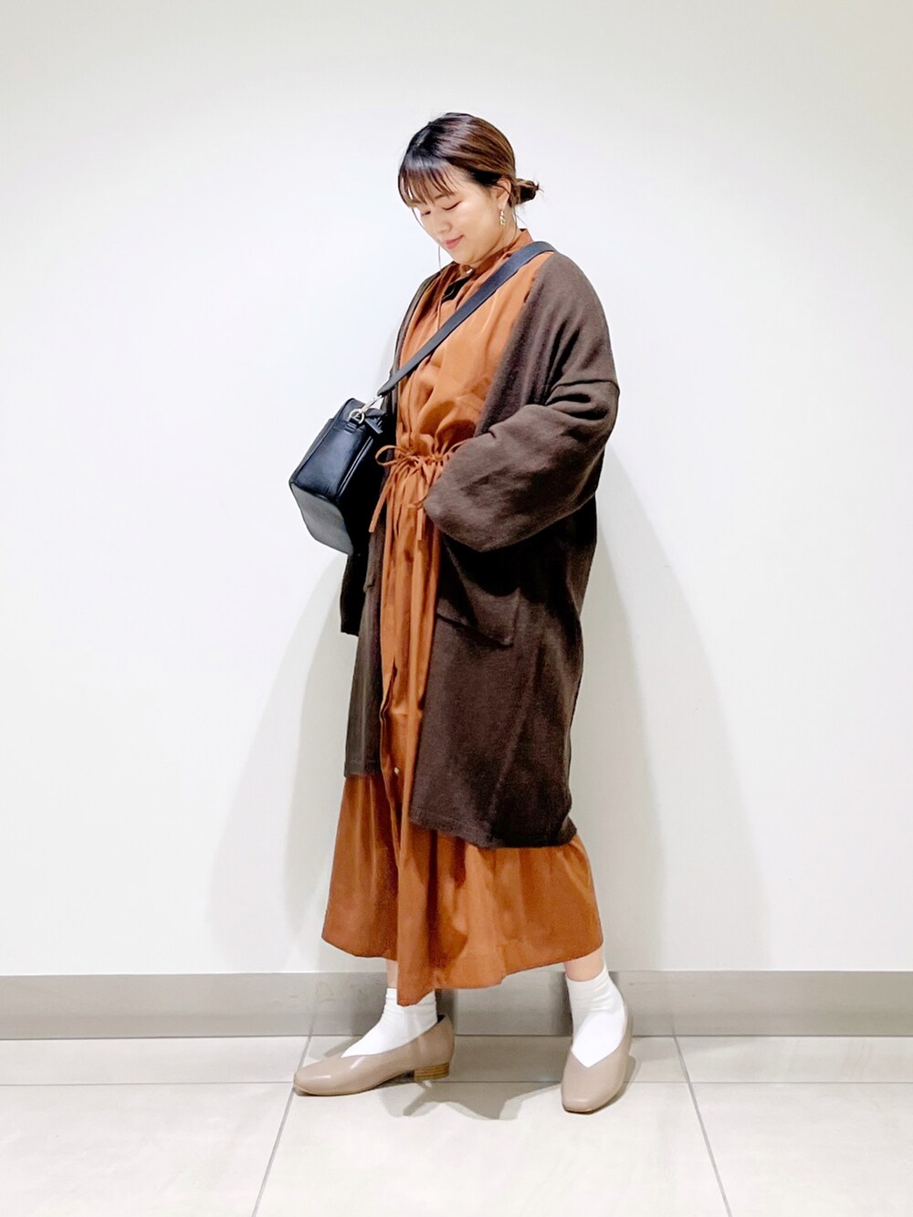 ブラウン系のカーディガン/ボレロ、イエロー系のワンピース、ブラック系のショルダーバッグを着用したレディースの秋コーディネートの5枚目の写真