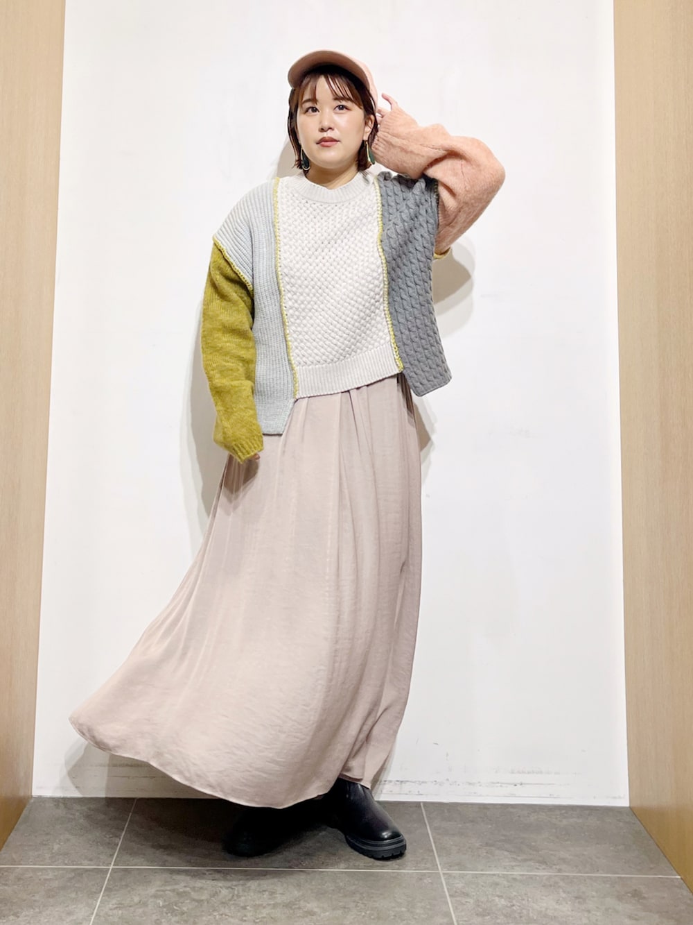 イエロー系のニット/セーター、グレー系のワンピース、ブラック系のブーツを着用したレディースの秋コーディネートの2枚目の写真