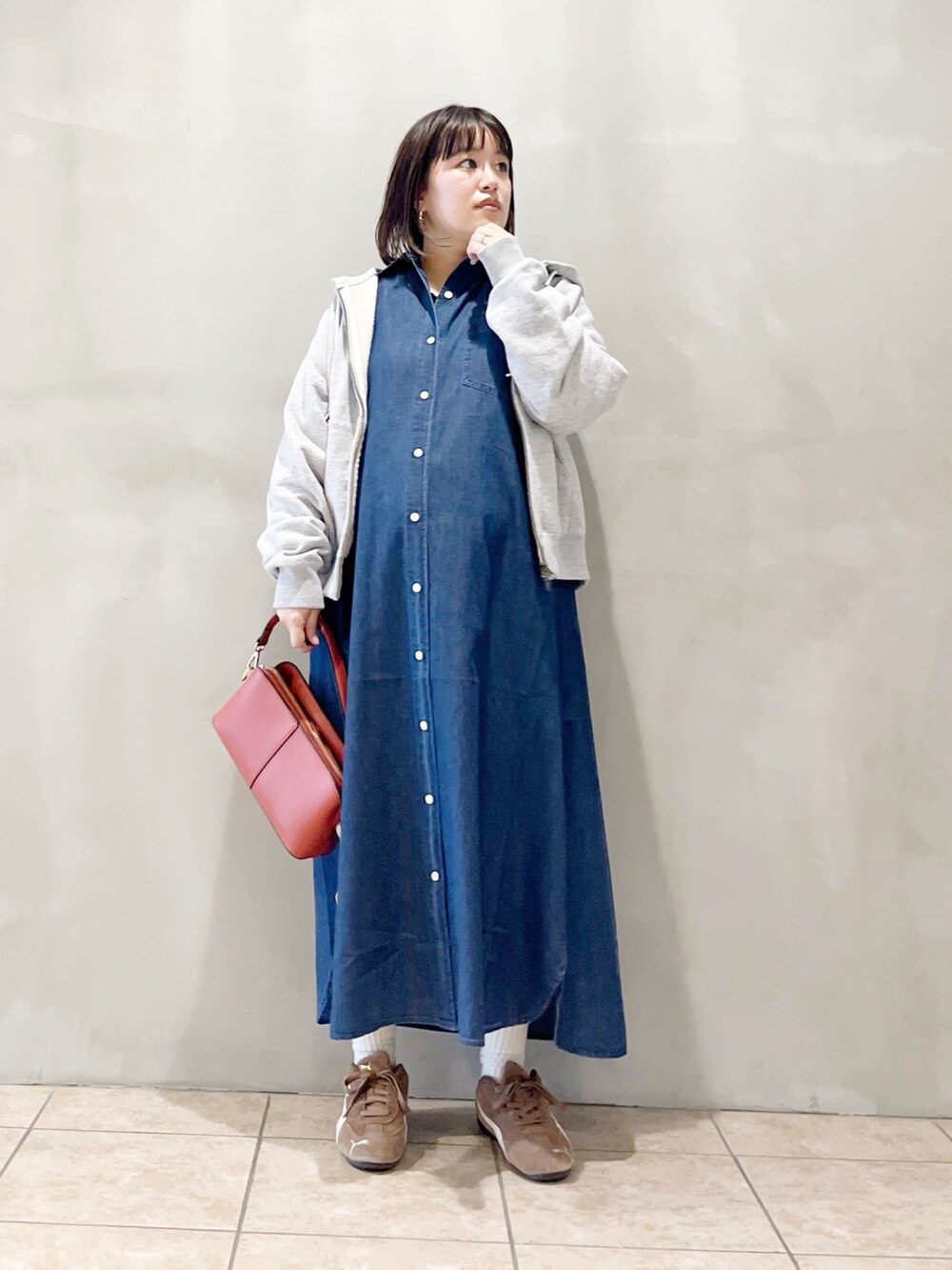 ブルー系のワンピース、オレンジ系のショルダーバッグ、ブラック系のスニーカーを着用したレディースの秋コーディネートの9枚目の写真