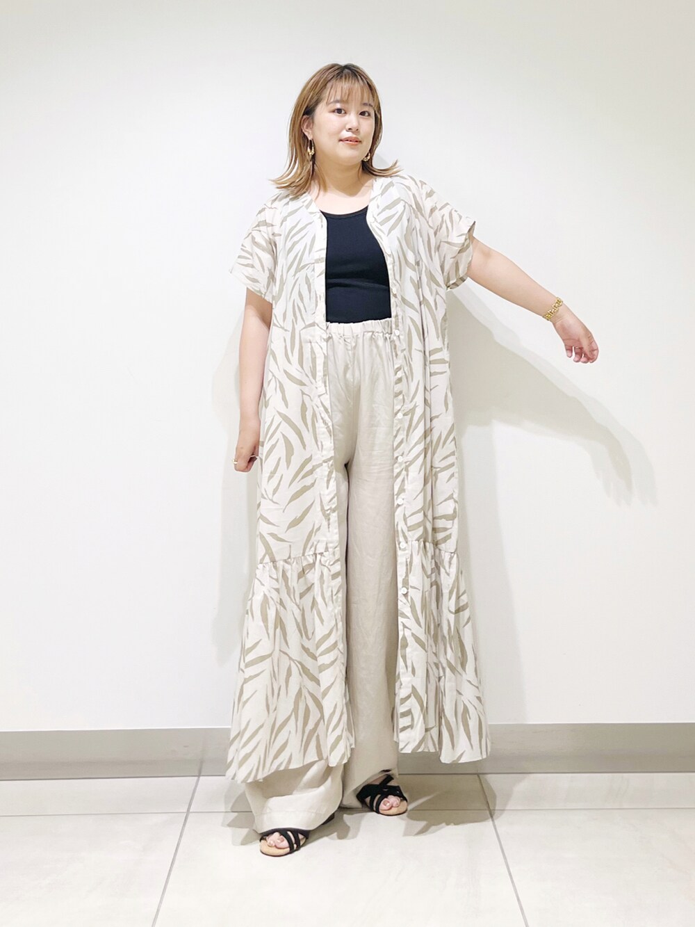 ベージュ系のワンピース、ベージュ系のその他パンツ、ブラック系のサンダルを着用したレディースの夏コーディネートの2枚目の写真