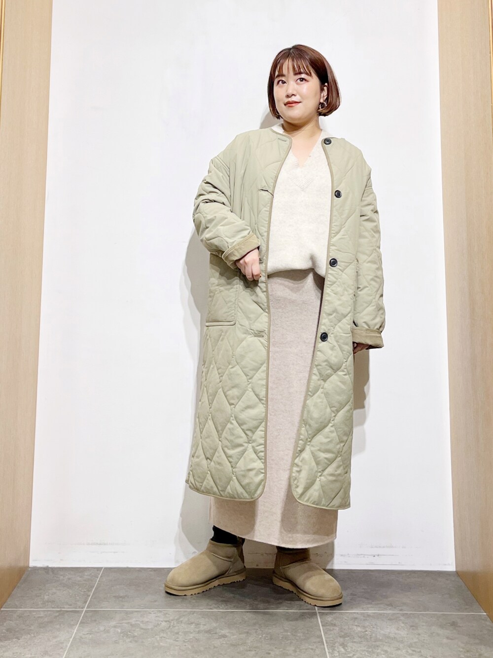 グリーン系のその他アウター、ベージュ系のスカート、グリーン系のブーツを着用したレディースの秋コーディネートの5枚目の写真