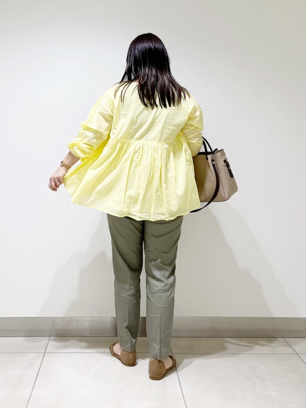 イエロー系のシャツ/ブラウス、グリーン系のその他パンツ、ベージュ系のトートバッグを着用したレディースの春コーディネートの2枚目の写真