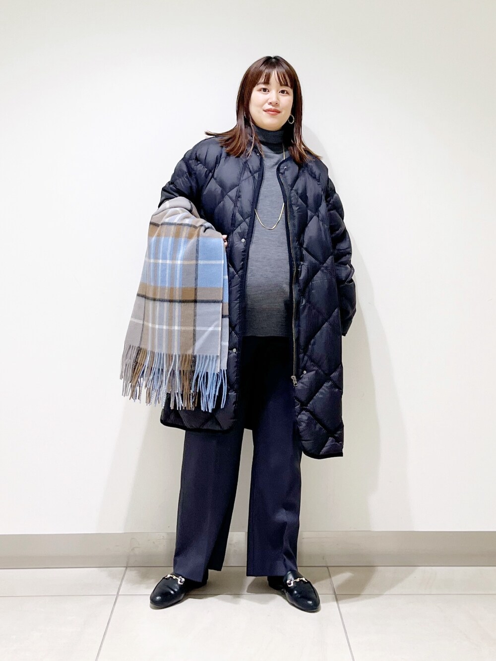 ブラック系のダウンジャケット/コート、グレー系のニット/セーター、グレー系のその他パンツを着用したレディースの冬コーディネートの3枚目の写真