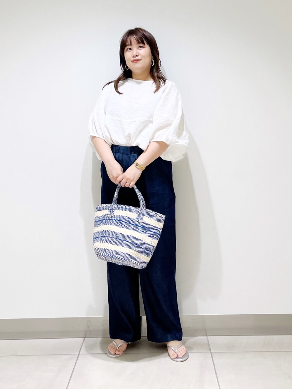 ホワイト系のシャツ/ブラウス、ブルー系のその他パンツ、ブルー系のハンドバッグを着用したレディースの夏コーディネートの2枚目の写真