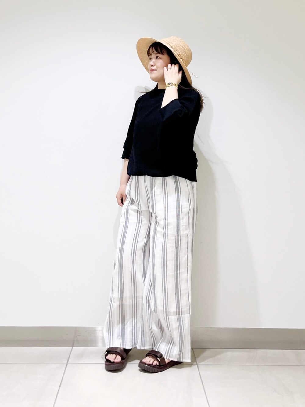 ブラック系のTシャツ/カットソー、ホワイト系のその他パンツ、ブラウン系のサンダルを着用したレディースの春コーディネートの5枚目の写真