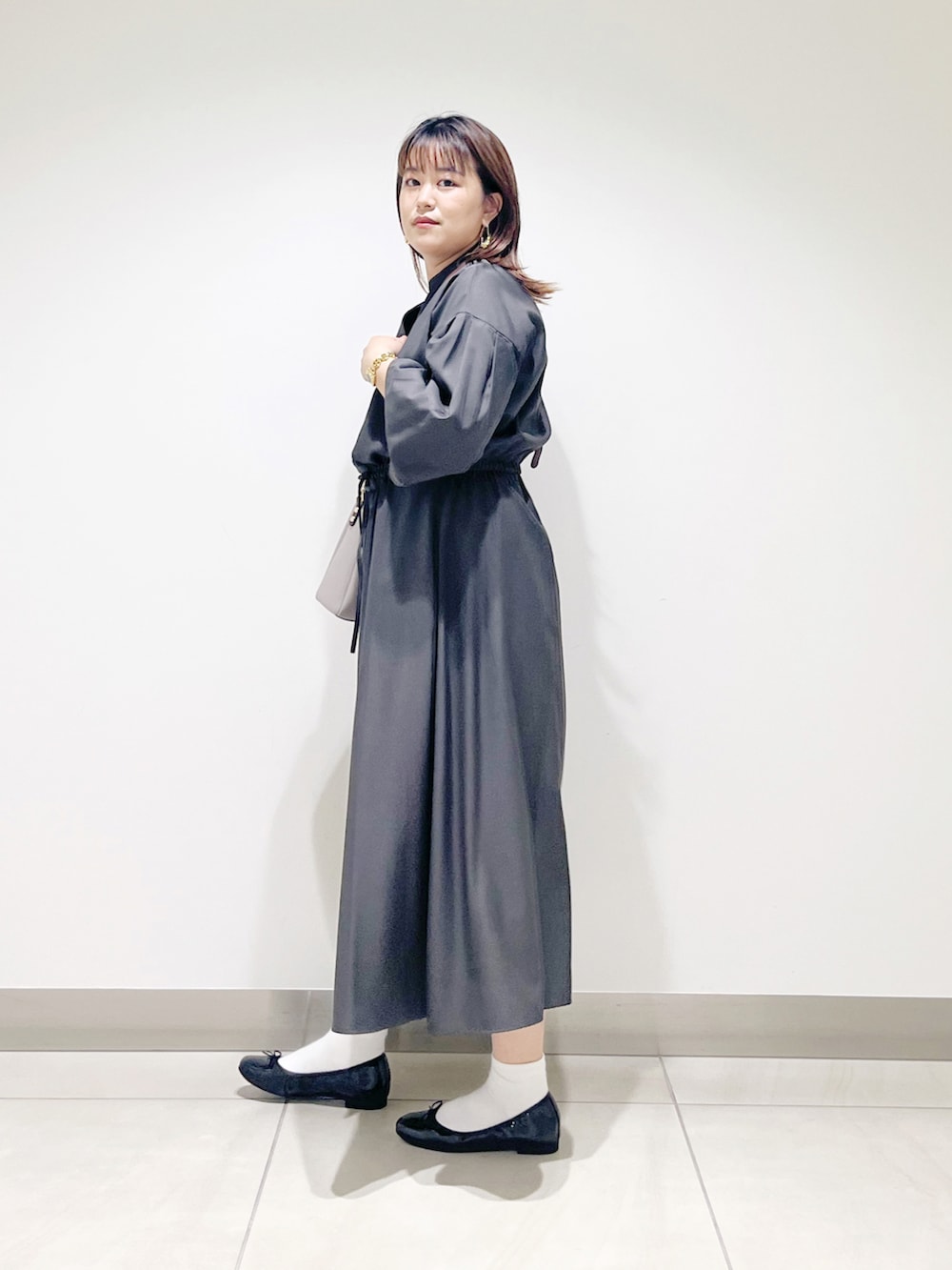 グレー系のワンピース、グレー系のショルダーバッグ、ブラック系のバレエシューズを着用したレディースの秋コーディネートの3枚目の写真