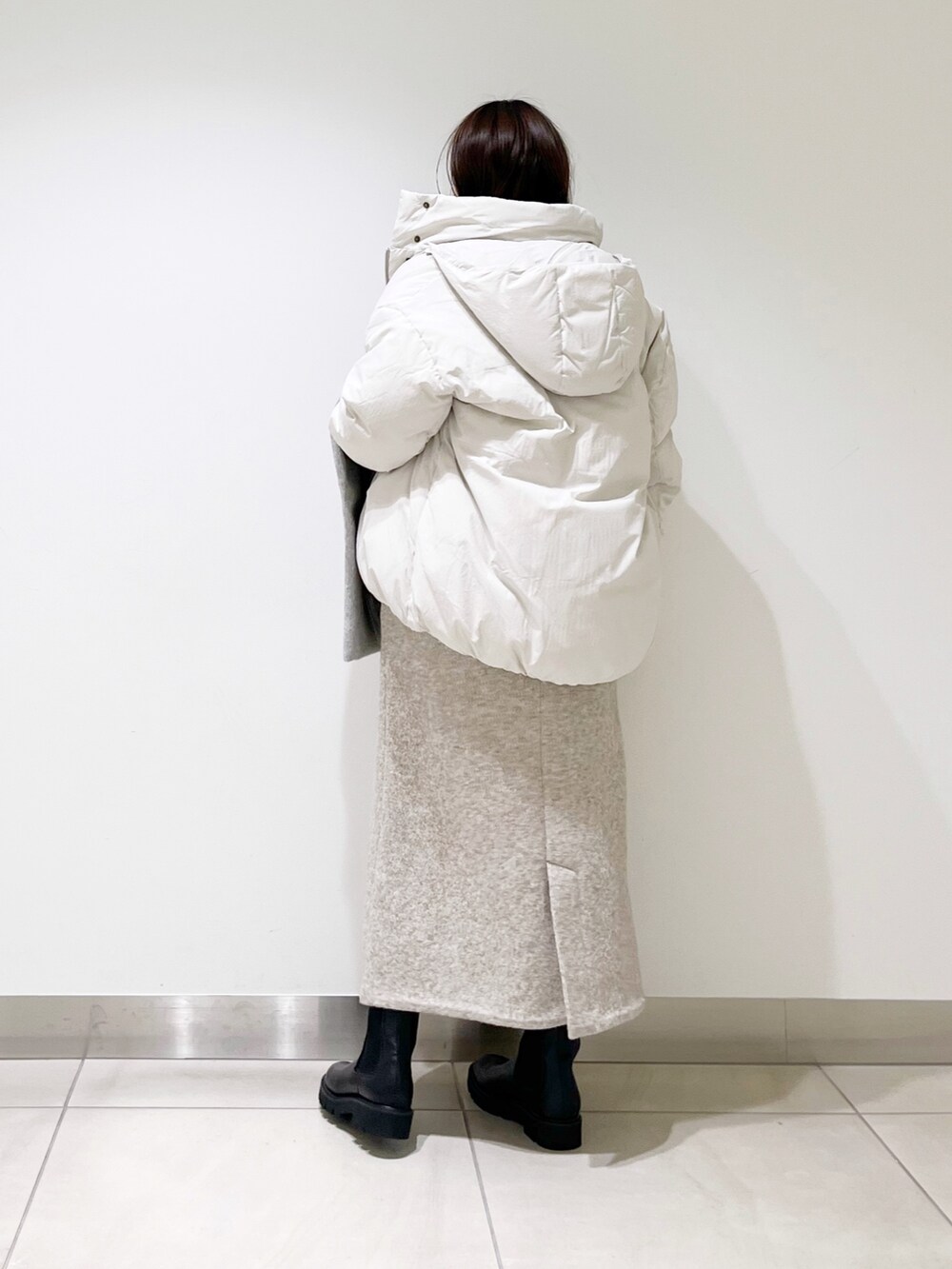 ホワイト系のダウンジャケット/コート、ベージュ系のワンピース、グリーン系のニット/セーターを着用したレディースの冬コーディネートの8枚目の写真