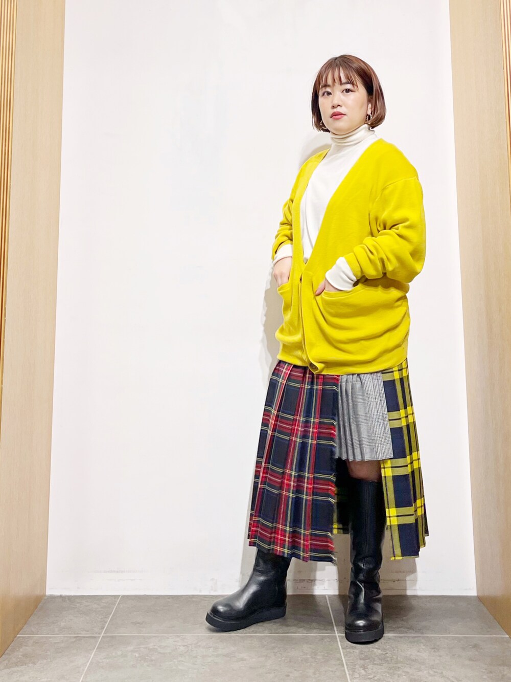 イエロー系のカーディガン/ボレロ、ホワイト系のニット/セーター、その他のスカートを着用したレディースの冬コーディネートの3枚目の写真
